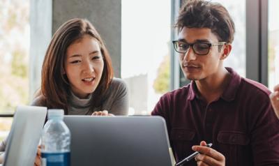 Adult students looking at a computer screen together