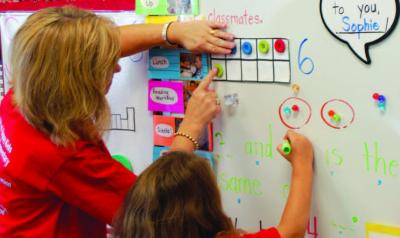 A teacher helps a child develop math concepts