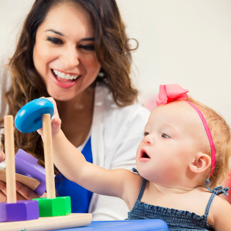 Teacher helping baby stack