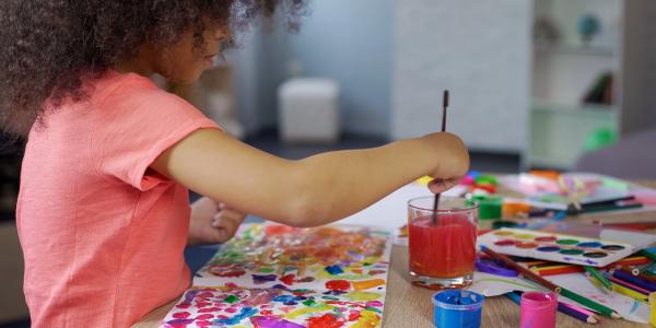 a young girl painting a picture